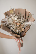 Load image into Gallery viewer, Bouquet of dried flowers wrapped in brown paper with a pink ribbon on a neutral background
