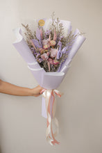 Load image into Gallery viewer, Bouquet of flowers wrapped in purple paper with a ribbon, held by a person against a plain background.
