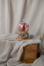 Load image into Gallery viewer, Decorative item with pink heart and white flowers under a glass dome on a wooden block with beige fabric background
