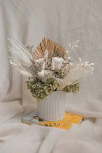 Decorative flower arrangement with a white vase on a soft surface