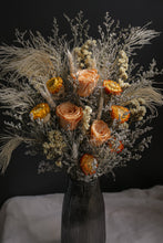 Load image into Gallery viewer, Vase arrangement of dried flowers with orange and beige tones in a dark vase against a black background.
